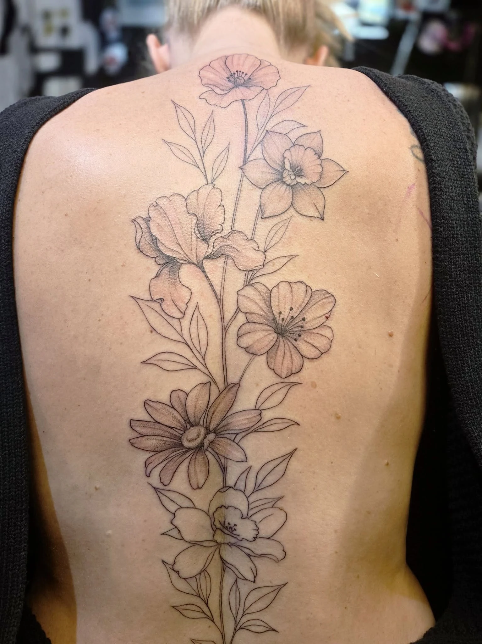 Fine-line floral back tattoo